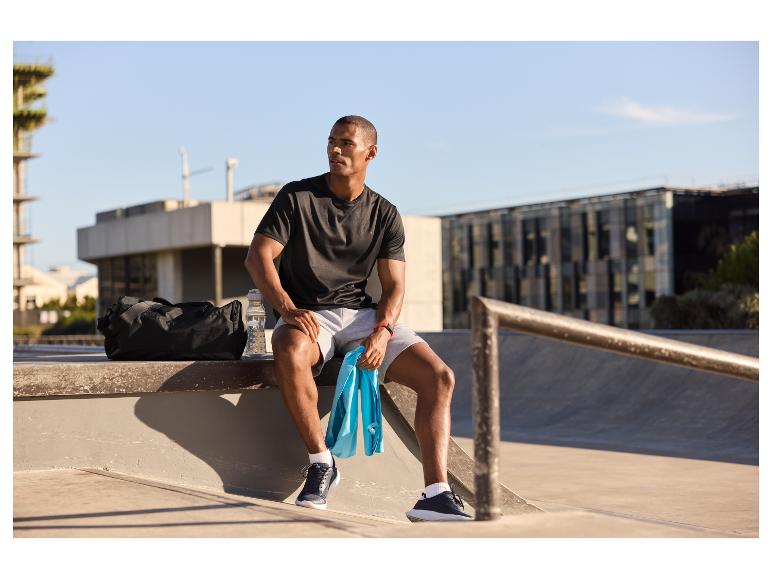 Atleet rustend na de training: sporttas, handdoek en waterfles.