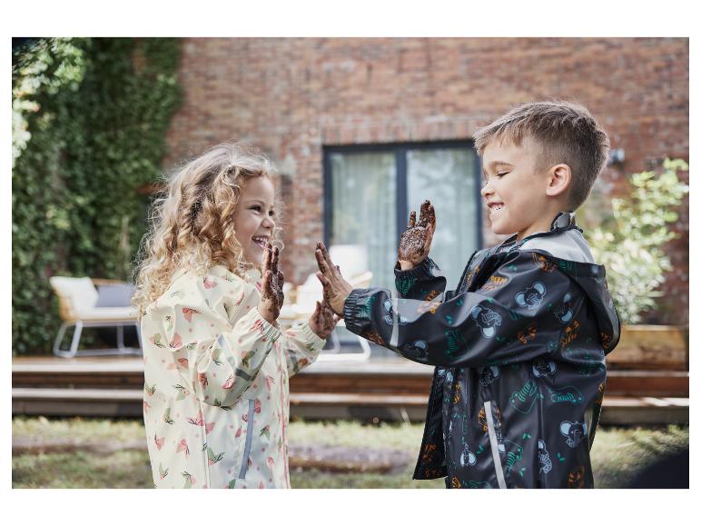 Twee kinderen met modderige handen dragen regenjassen met vlinder- en dierprint.