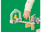 Kinderhand speelt met een houten bel en knikkerbaan op een groene achtergrond.
