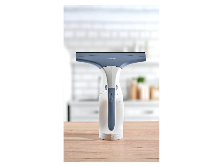 Silvercrest elektrische raamreiniger op een houten tafel met een wazige keukenachtergrond.