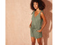 Een vrouw draagt een groene jumpsuit met strikjes.