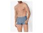 Man zonder shirt in blauwe boxershorts met een witte en blauwe elastische band.