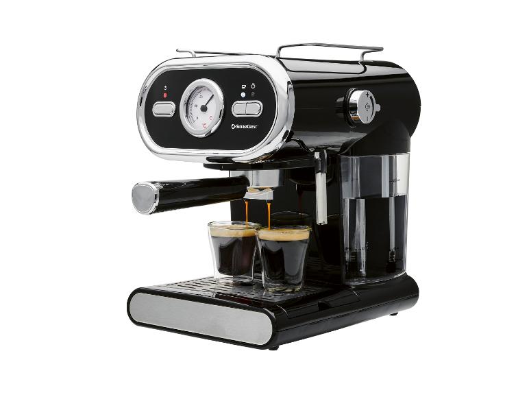 Zwart espressomachine met chromen details, die twee koffies in glazen kopjes zet.