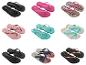 Negen paar teenslippers in diverse kleuren en patronen, waaronder zwart, roze, luipaardprint en gestreept.