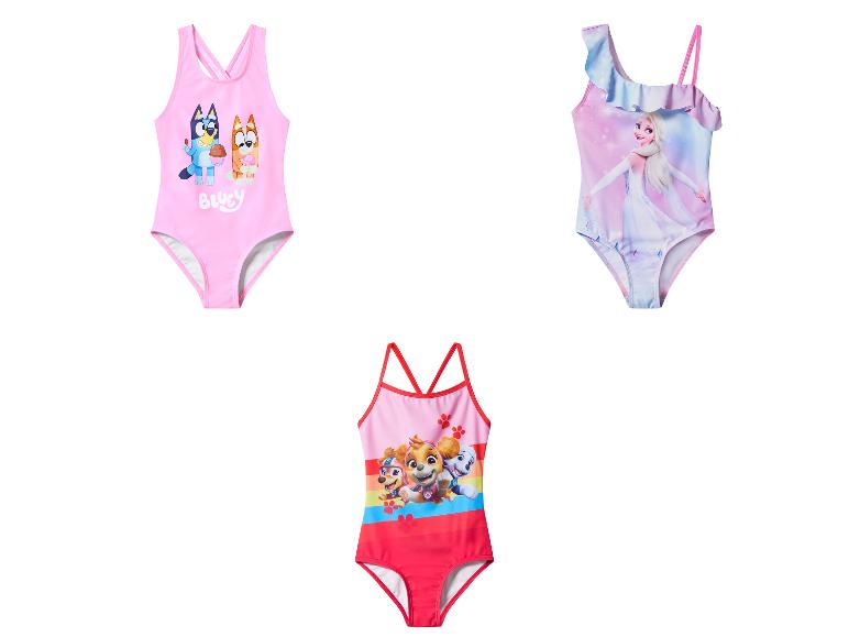 Drie meisjeszwempakken: roze met tekenfilmhonden, blauw met prinses en rood met puppy's.