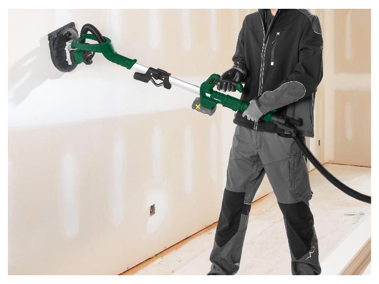 Man schuurt een muur met een Parkside draadloze wandschuurmachine.