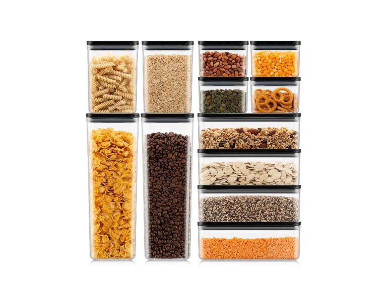 Diverse voedingsmiddelen opgeslagen in transparante containers, waaronder pasta, granen en noten.