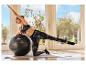 Vrouw in CRIVIT sportlegging traint met een fitnessbal.