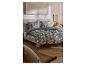 Bed met donkergroen bloemenbeddengoed en kussens, met een houten nachtkastje.