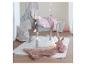 Grijs houten paard met roze deken, roze bontkleed en knuffelkonijn in een kinderkamer.