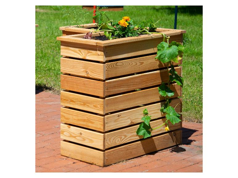 Houten plantenbak met diverse planten, waaronder goudsbloemen en een komkommerplant