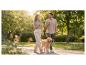 Koppel wandelt met een golden retriever in een park, genietend van de zon.