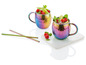 Twee regenboogkleurige Moscow Mule bekers met ijs, limoen en frambozen, twee metalen rietjes.