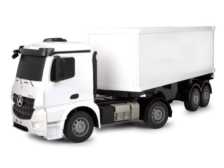 Wit speelgoedmodel van een Mercedes Arocs vrachtwagen met een witte aanhanger.