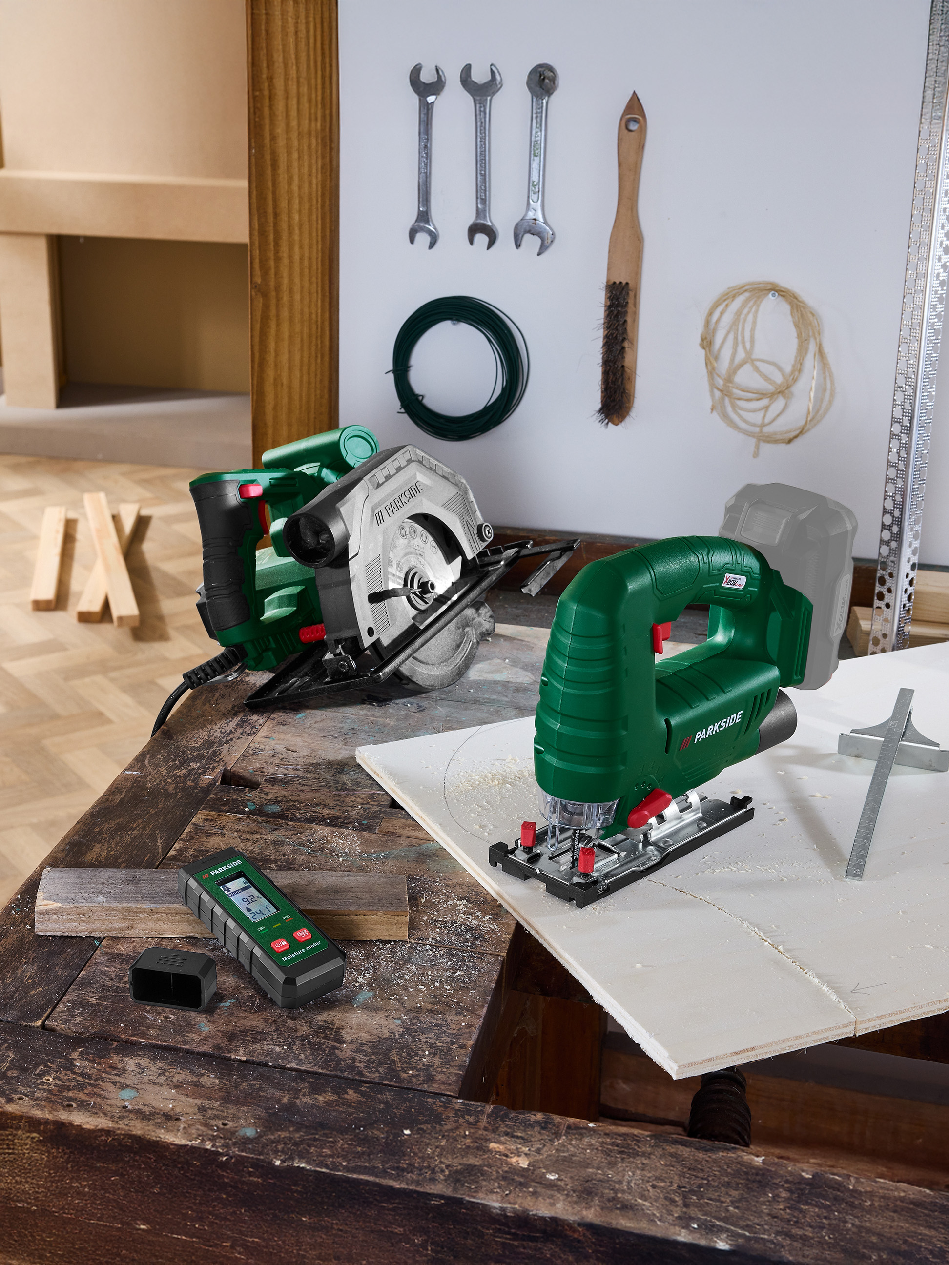 Gereedschap op een werkbank: cirkelzaag, decoupeerzaag en vochtmeter.