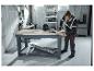 Man in PARKSIDE PERFORMANCE® waarschuwingssweatjack boort in een werkplaats.