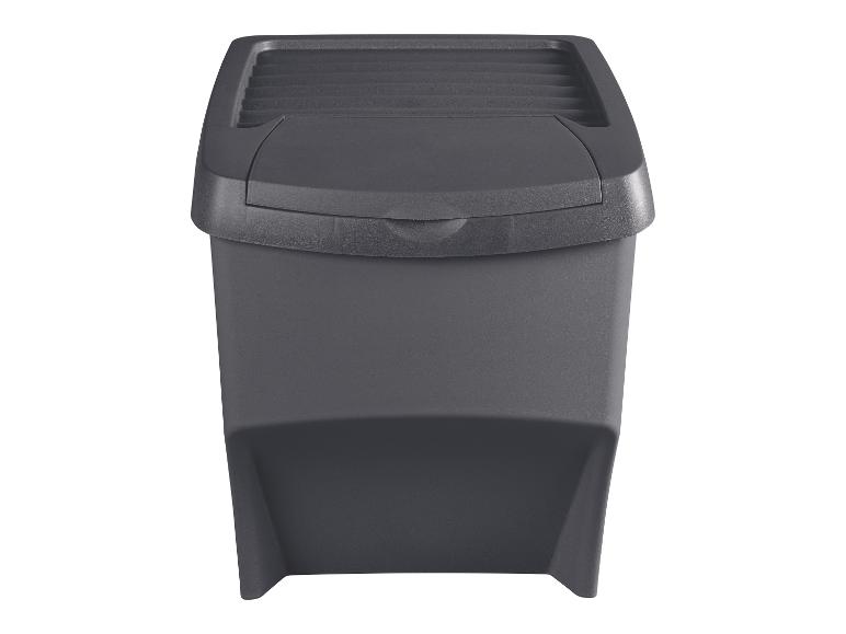 Donkergrijze plastic afvalbak met zwenkdeksel, geïsoleerd op een witte achtergrond.