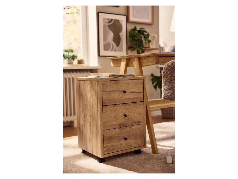 Houten mobiel ladeblok met drie laden naast een bureau in een thuiskantoor.