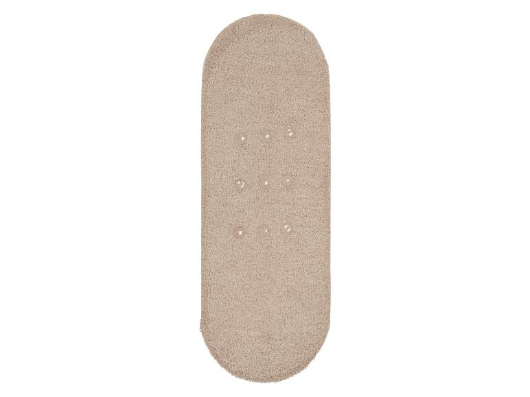 Beige ovaal badmat, zacht en fluffy.