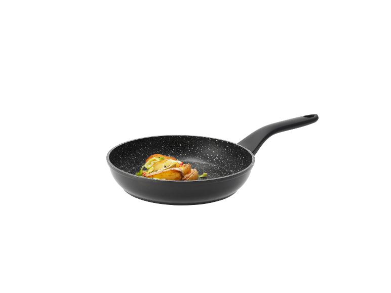 Zwarte koekenpan met geroosterde aardappelen en groenten