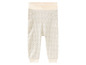 Beige broek met donkergrijze stippen.