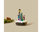 Verlichte kersttafeldecoratie met twee kinderfiguren en een kerstboom.