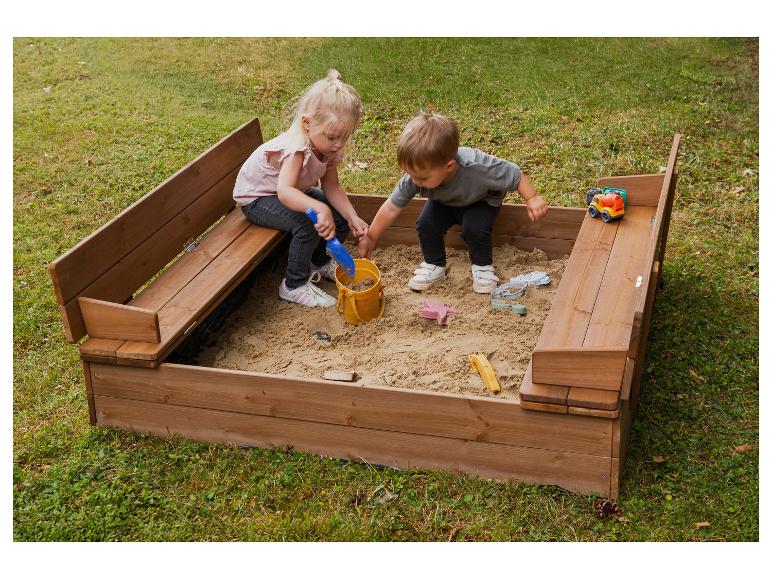 Twee kinderen spelen in een houten zandbak met bankjes.