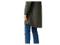 Een vrouw draagt een lange, olijfgroene jas en jeans.