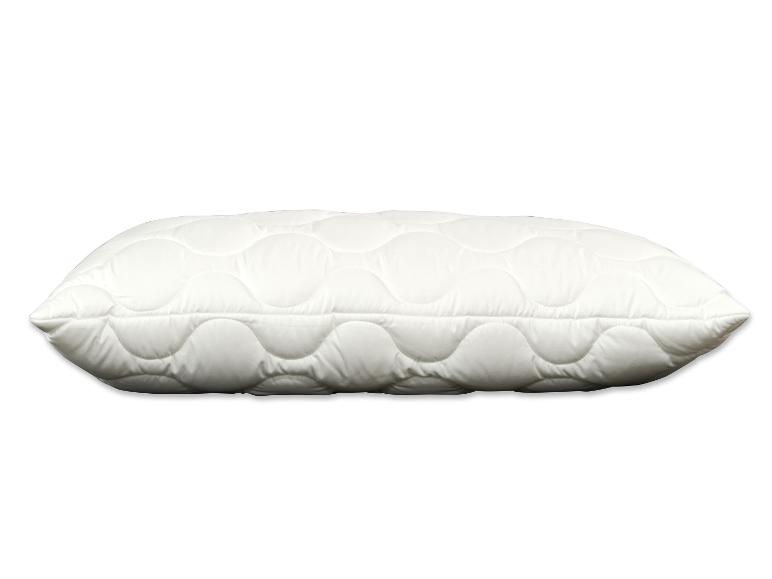 Wit gewatteerd kussen met golvend patroon op een witte achtergrond.