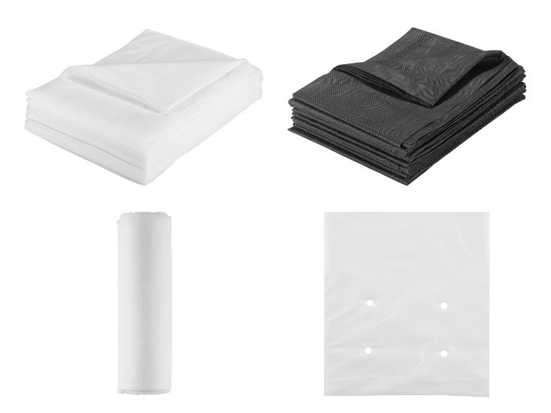 Stapel wit en zwart non-woven textiel, een rol papier en een plastic zak.