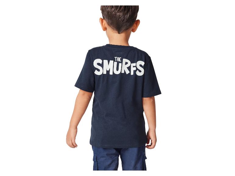 Een jongen draagt een donkerblauw T-shirt met de Smurfen erop.
