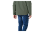 Een man in een olijfgroen jack en blauwe jeans.