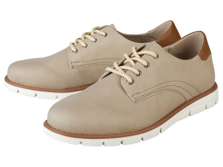 Een paar beige leren herenschoenen met veters.