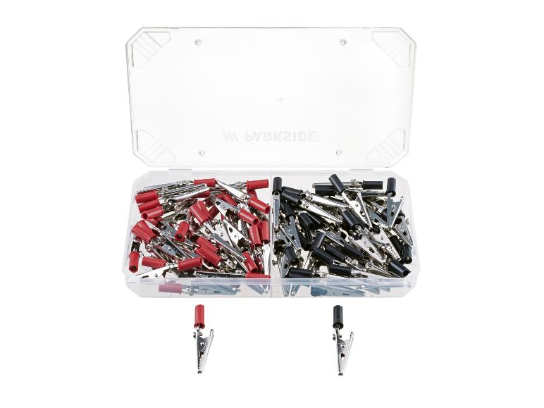 Doos met rode en zwarte krokodillenklemmen, met twee klemmen eronder.