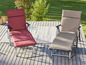 Twee ligstoelen met kussens op een houten terras.