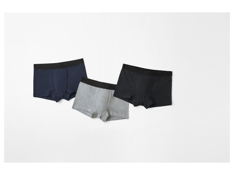 Drie paar boxershorts in verschillende kleuren.