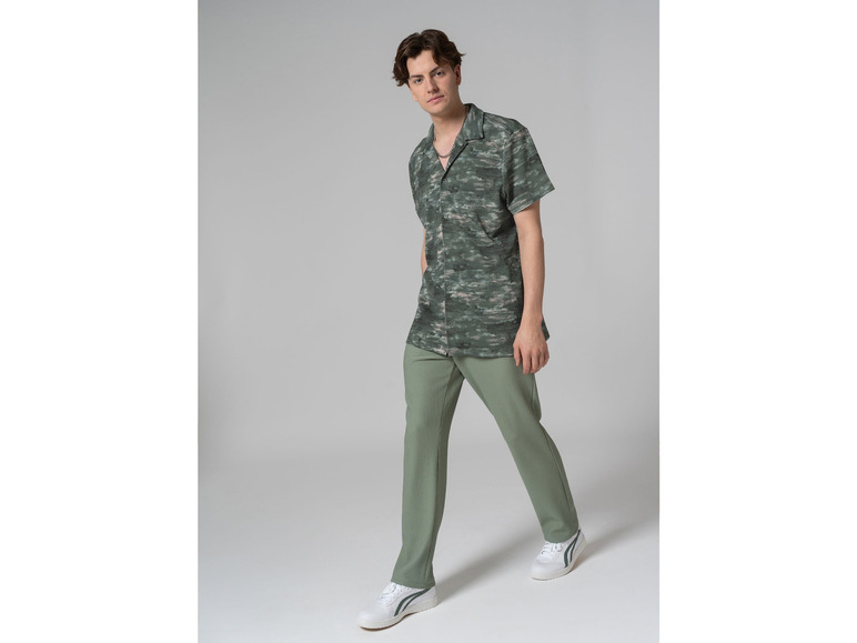 Man in groene broek en een camouflagehemd.