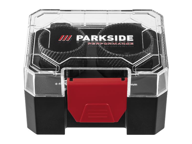 Een zwarte en transparante plastic opbergdoos met een rode sluiting, met twee zwarte schuurschijven.