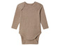 Een beige baby romper met lange mouwen.