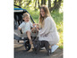 Een vrouw met een kind in een Ergobaby-kinderwagen en een Franse bulldog.