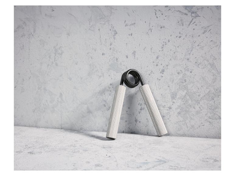 Een handgreep voor het trainen van de grip op een betonnen achtergrond.