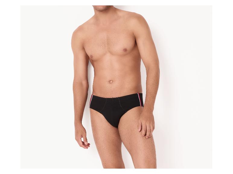 Man in zwarte slip met rood-witte streep aan de zijkant.
