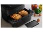 Zwarte Philips airfryer met twee hele kippen en groenten.