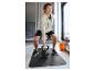 Man in hoodie en korte broek, tilt een 10 kg kettlebell op een vloermat.
