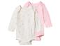 Twee rompertjes met lange mouwen: één wit met roze madeliefjes en één effen roze.