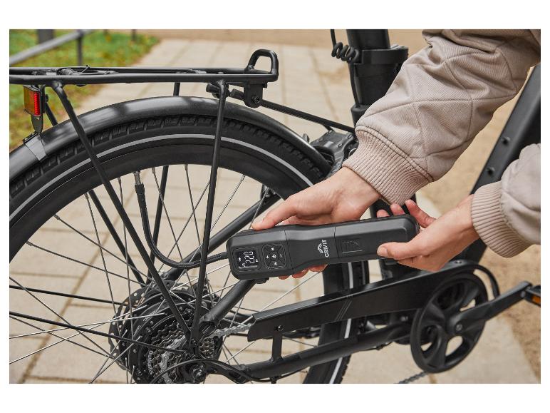 Persoon pompt fietsband op met een draagbare Crivit luchtpomp.