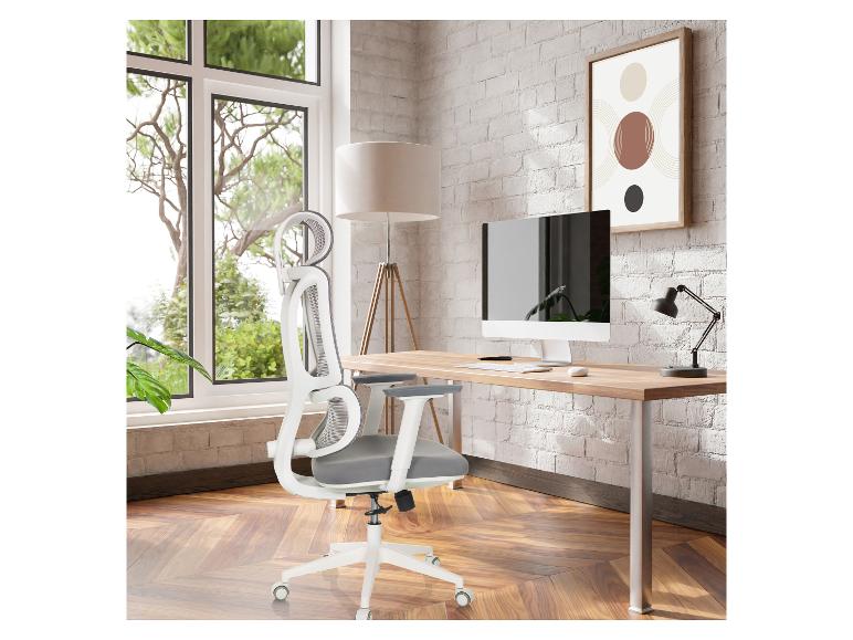 Witte ergonomische bureaustoel en houten bureau met computer in een thuiskantoor.