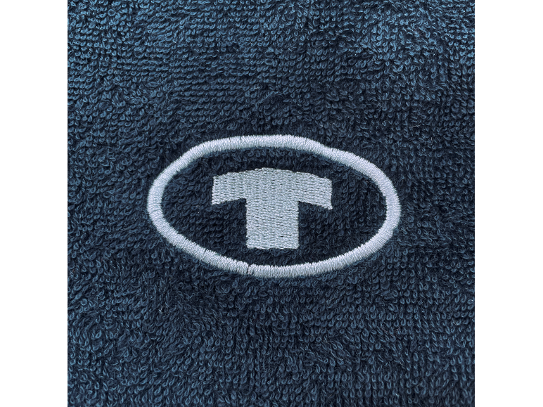 Geborduurd T-logo in een ovaal op donkerblauwe badstof.