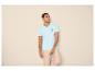 Man in een lichtblauw T-shirt met palmboomprint en beige broek
