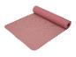 Een roze yogamat met textuur, opgerold.